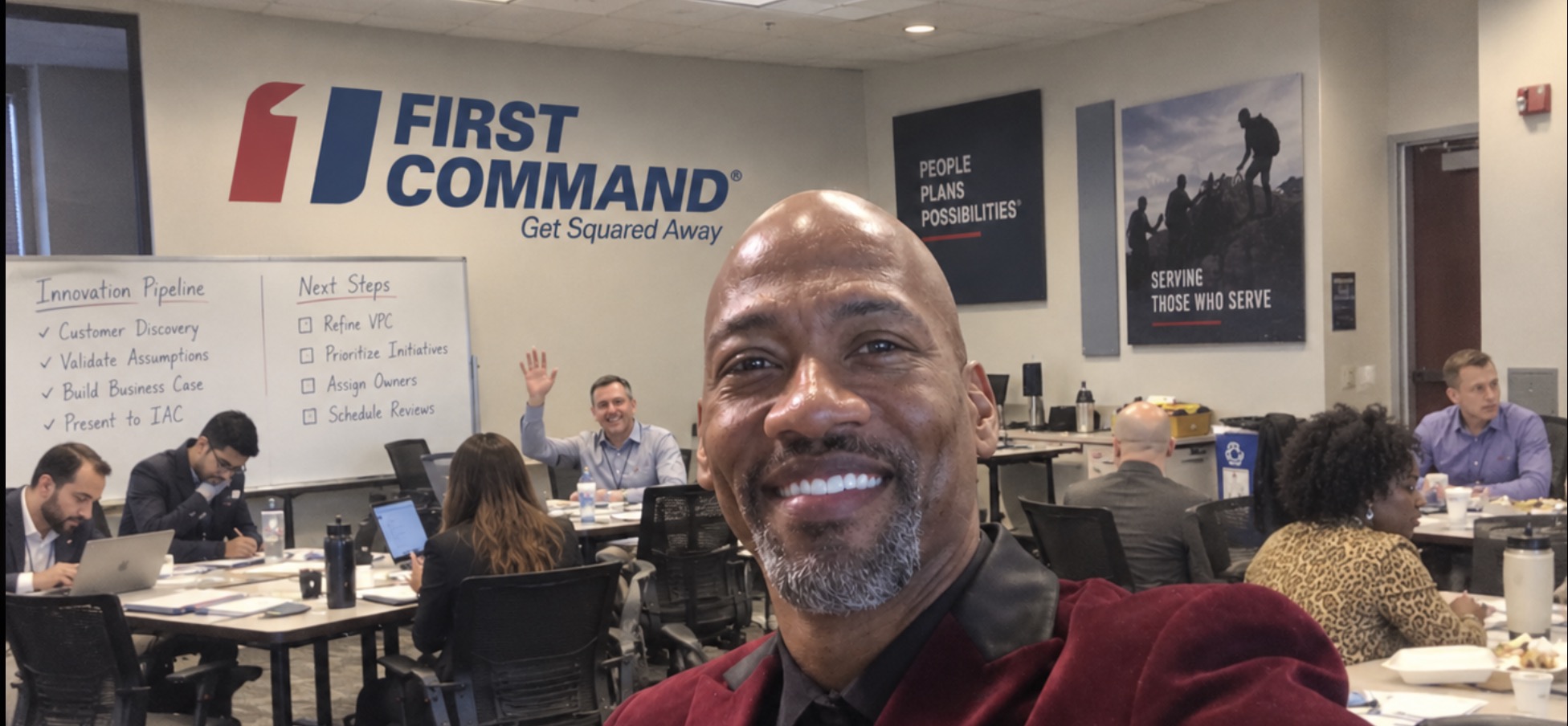 EzRã Masters at a First Command innovation workshop, with colleagues collaborating in the background beneath the First Command logo and a whiteboard showing the Innovation Pipeline and Next Steps